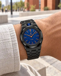 Cinturino in acciaio nero indossato al polso con l'AP x Swatch Royal Pop Orenji Hachi